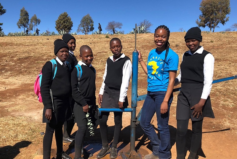Alexis poses with students in Lesotho